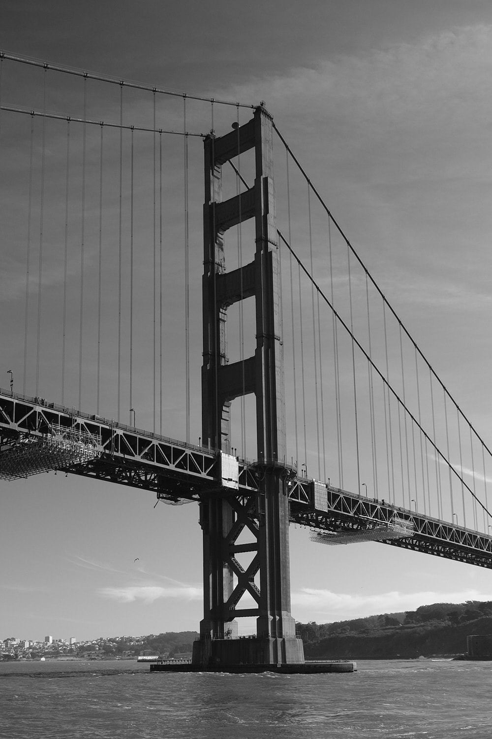 Black and white portrait photo of one of the towers of the Golden Gate Bridge.