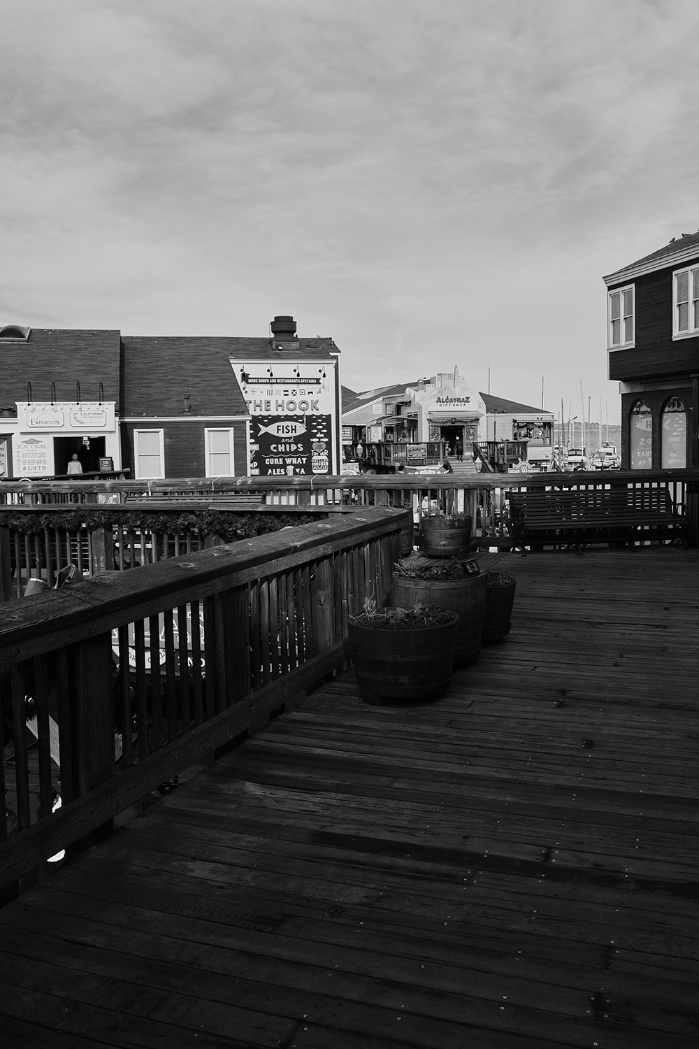Black and white portrait photo of some building and restaurants on Pier 39 of Fisherman's Wharf.