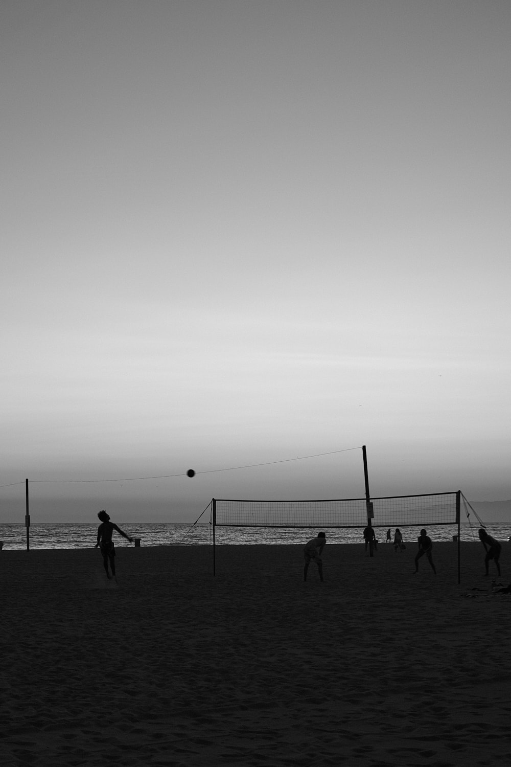 Black and white portrait photo of friends playing volleyball on the Venice Beach.